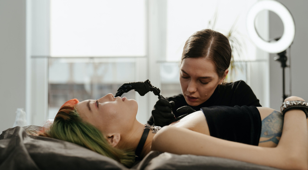 femme tatoueuse qui va tatouer la poitrine d'une femme